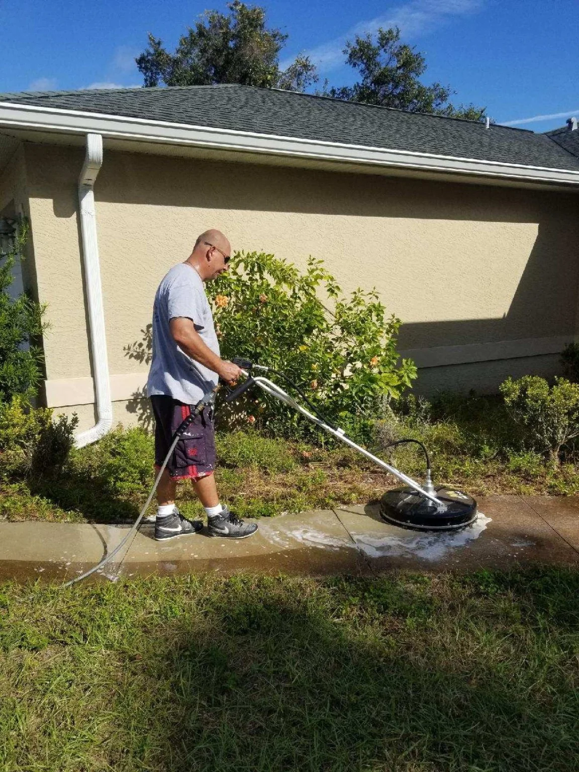 Robert using a surface cleaner on a walkway